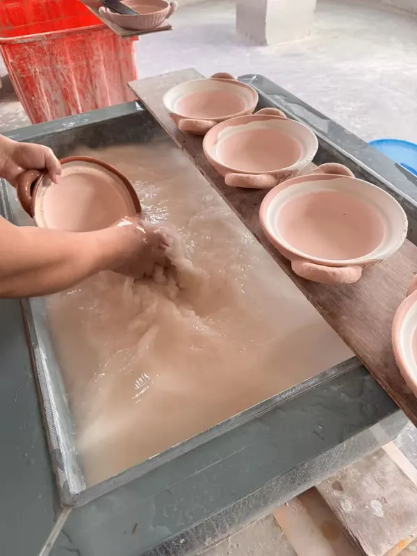 Unfired pots smoothed by hand with water.